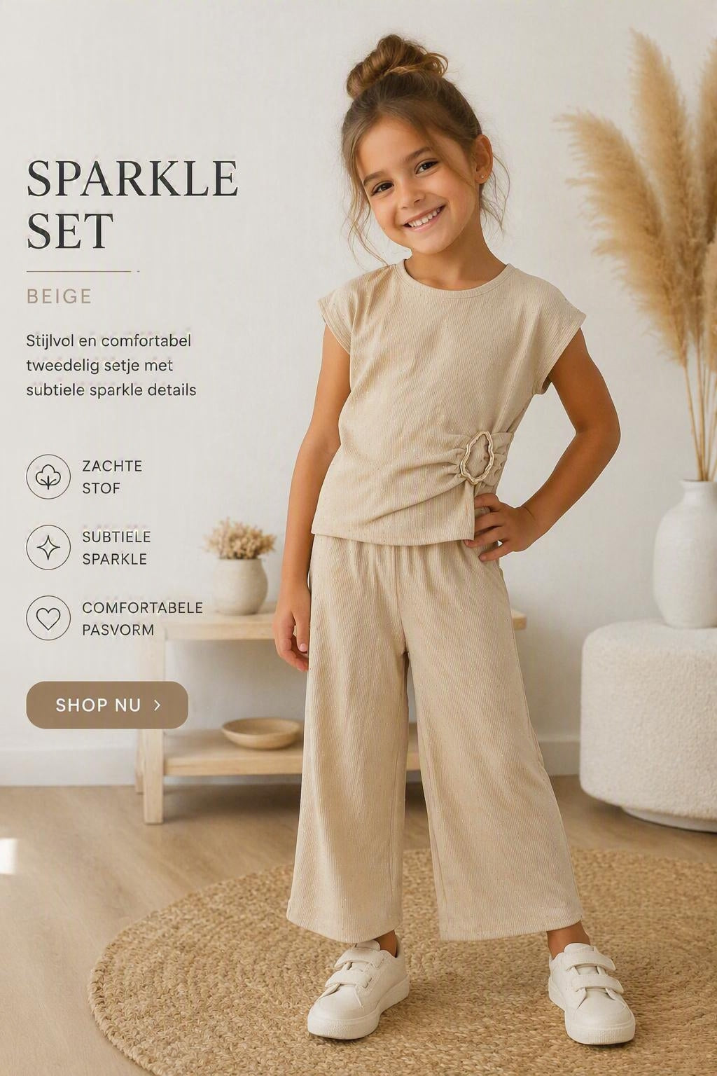 Kindmodel draagt een stijlvolle beige sparkle kinder set met korte mouwen en wijde broek. Comfortabele 2-delige outfit met subtiele glitterdetails, gefotografeerd in een lichte webshopsetting.