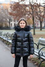 ICON meisjes winterjas zwart met bontkraag gedragen in stadspark tijdens herfst