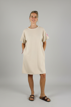 Dames beige midi jurk met korte mouwen, zijzakken en fuchsia label patch — casual chique jurk voor dames op lichtgrijze studio achtergrond, Life Label maxi jurk beige