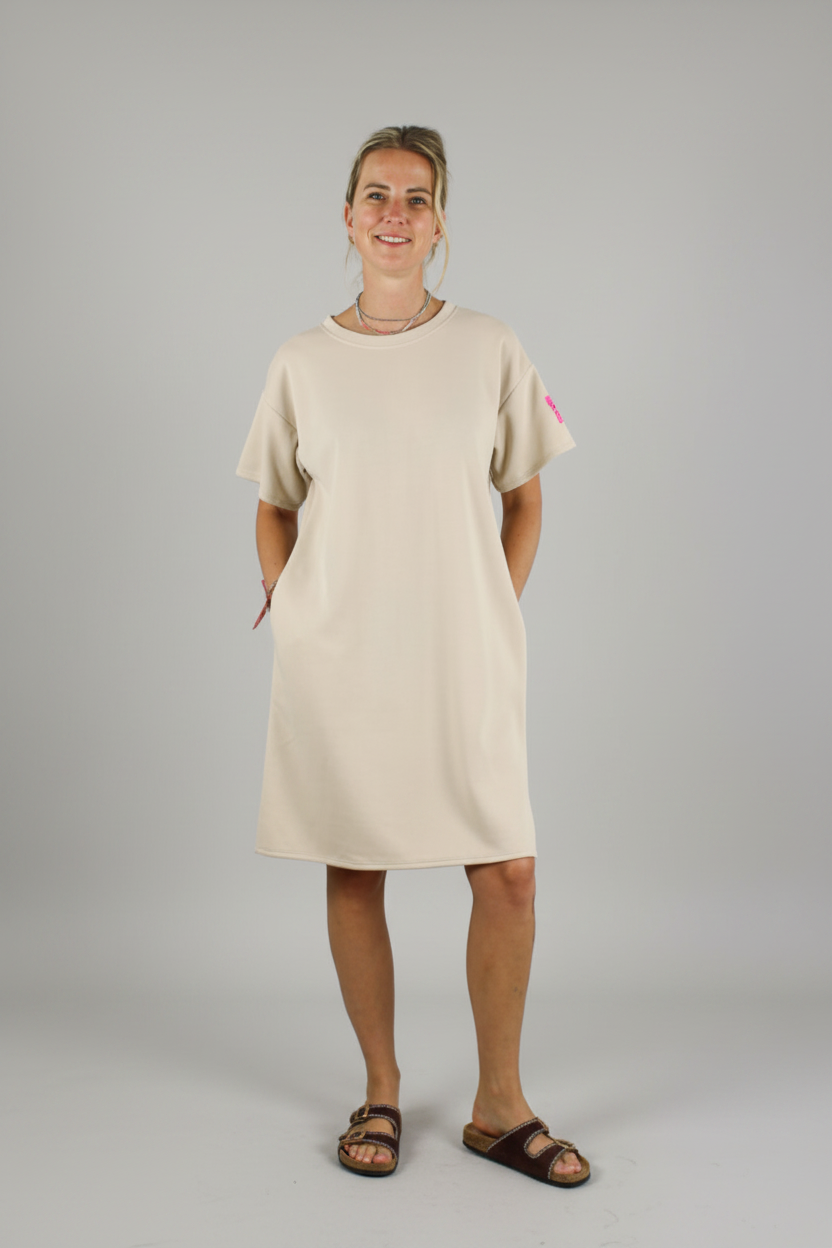Dames beige midi jurk met korte mouwen, zijzakken en fuchsia label patch — casual chique jurk voor dames op lichtgrijze studio achtergrond, Life Label maxi jurk beige
