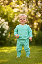 ICON baby mintgroen setje met sweater en joggingbroek - model 18 maanden - tuin achtergrond | DeNa Fashion