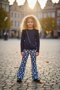 Meisjes flared broek geometrische print blauw met navy top lifestyle blond krullend meisje 6 jaar stadsplein