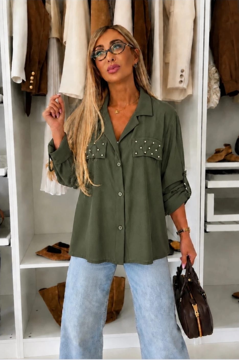 Kaki dames blouse met pareldetails op de borstzakken, lange mouwen en knoopsluiting gecombineerd met een lichtblauwe jeans.